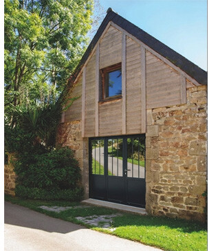 Porte de garage battante Reflet aluminium (LE NOUY) posée sur une longère en pierre, en rénovation dans le Cap-Sizun